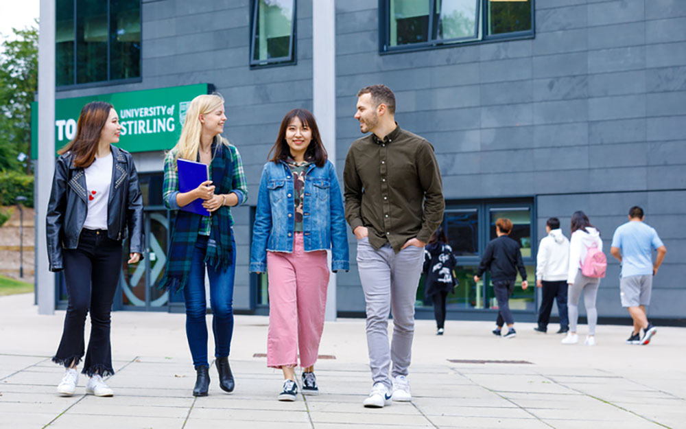 Chinese students walking outside INTO building with European students